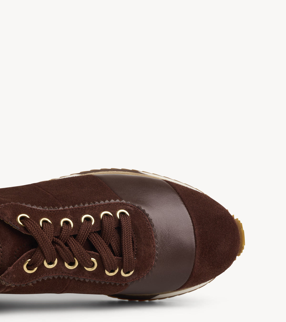 The Quinn Sneaker — close-up of the lacing and stitching on the brown suede sneakers